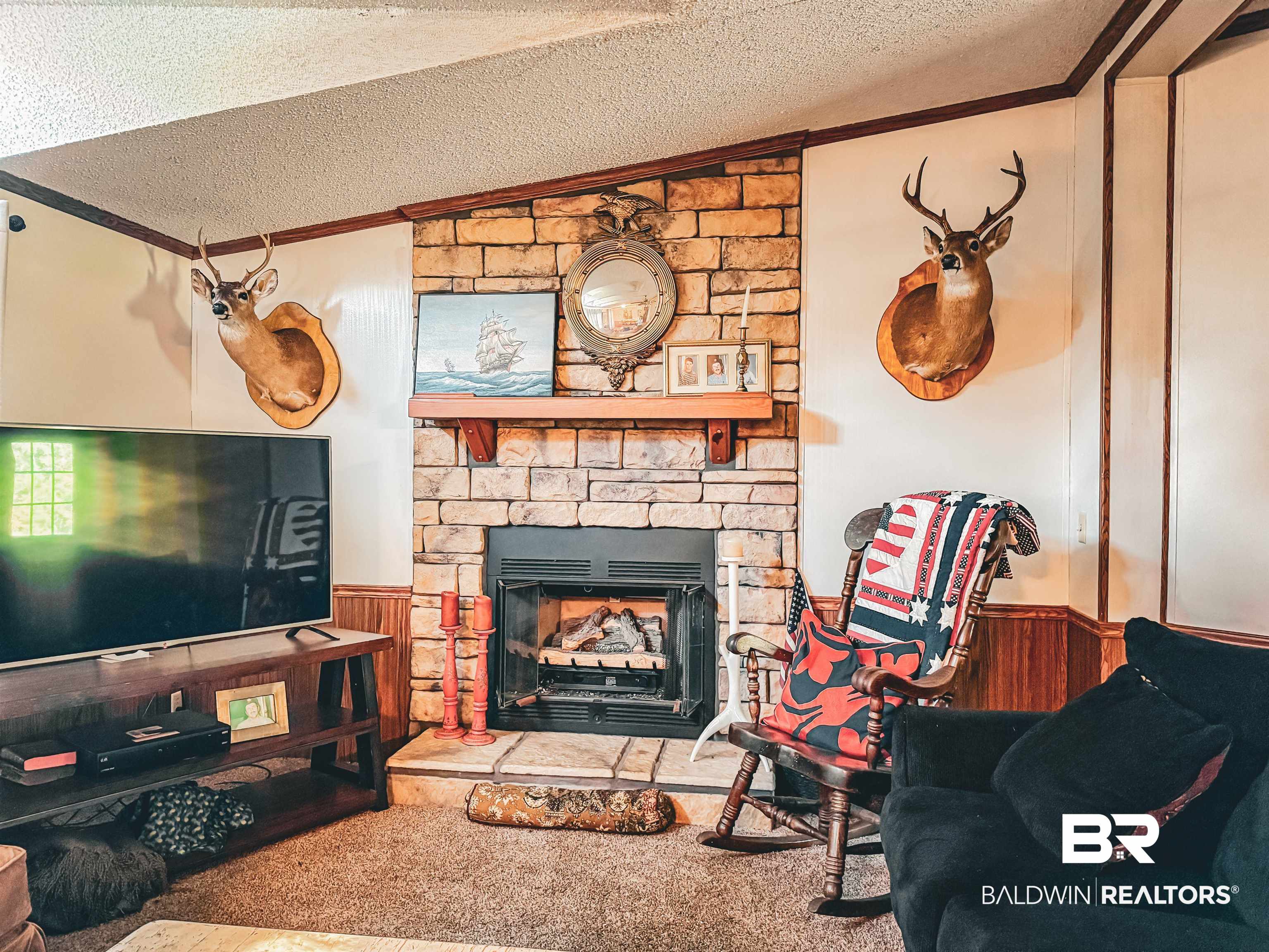 3346 Hoomesville Road Brewton, AL 36426 - Photo 10 of 16 Living room with wainscoting, wooden walls, a textured ceiling, crown molding, and a fireplace