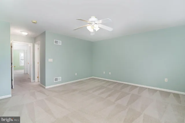an empty room with fan and entrance