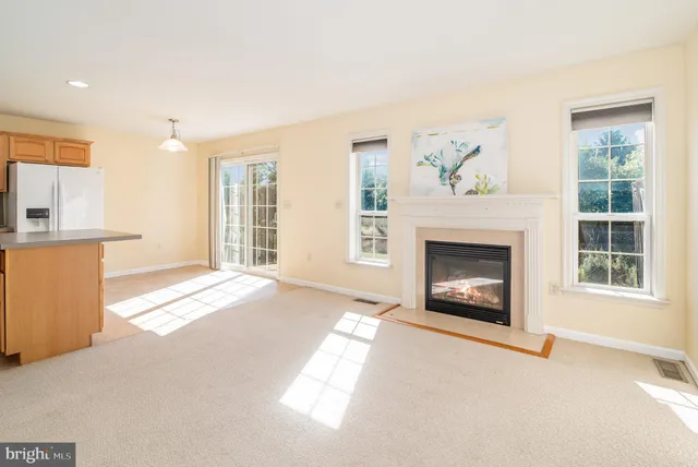 a view of an empty room with a fireplace and a window