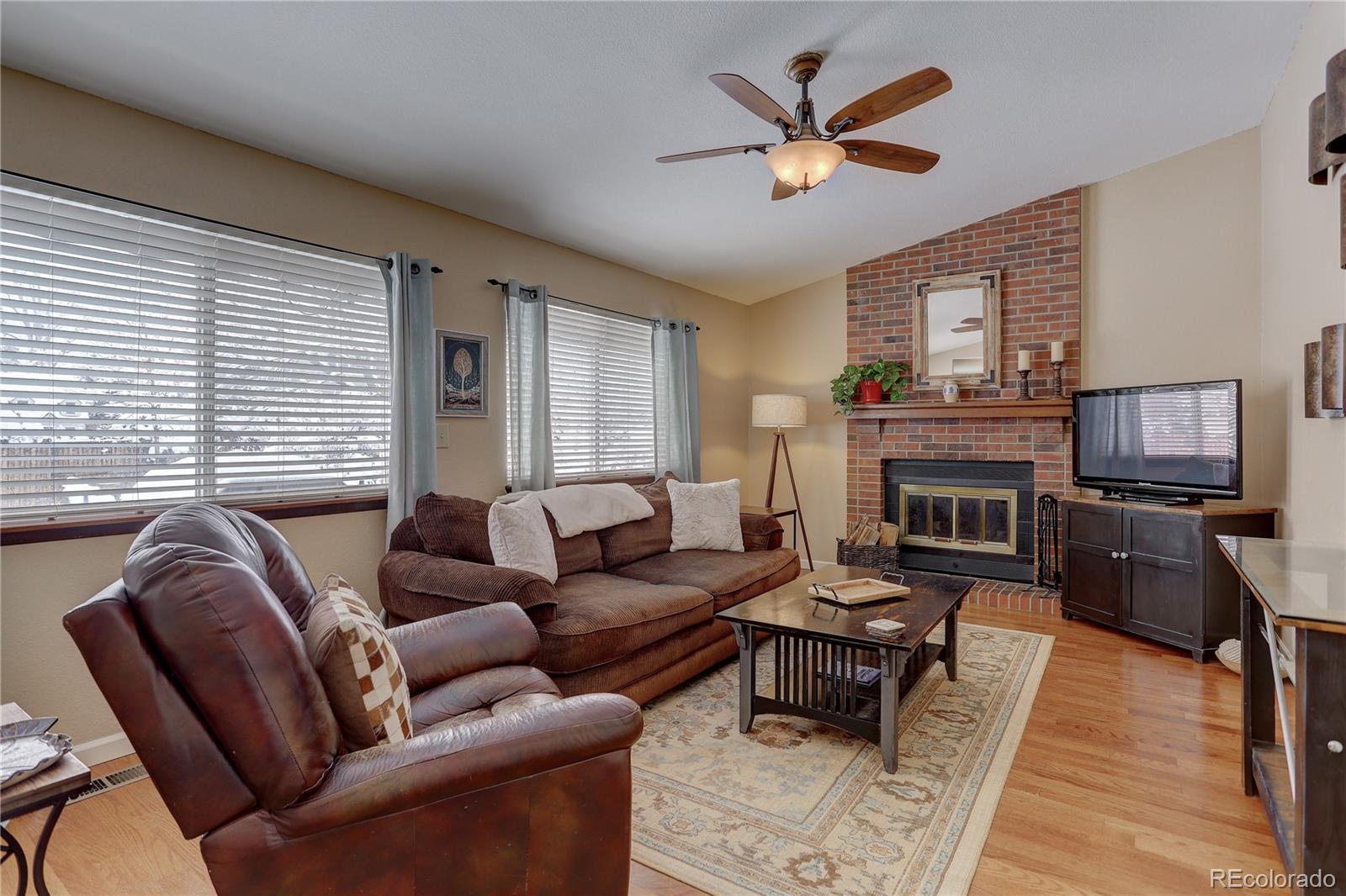 431 Mountain Chickadee Road Highlands Ranch, CO 80126 - Photo 14 of 38 a living room with furniture a fireplace and a flat screen tv