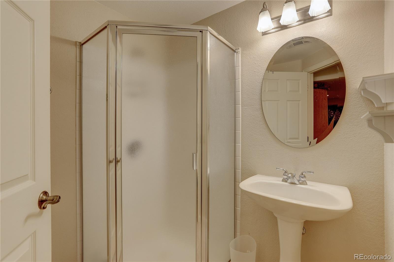 431 Mountain Chickadee Road Highlands Ranch, CO 80126 - Photo 32 of 38 a bathroom with a sink a mirror a vanity and a shower