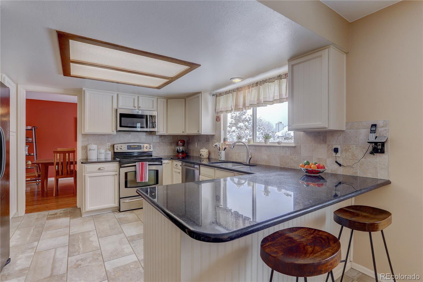 431 Mountain Chickadee Road Highlands Ranch, CO 80126 - Photo 9 of 38 a kitchen with a stove a sink and a refrigerator