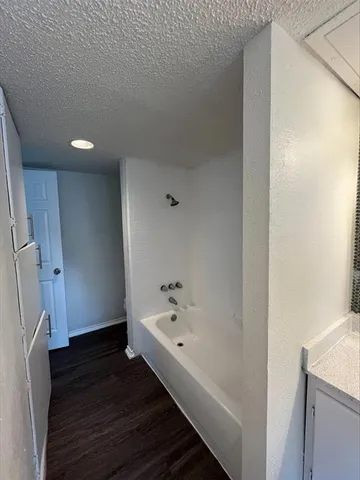 a hallway with wooden floor and stairs