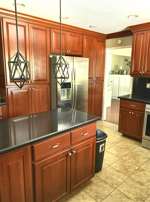 62 Pepper Tree Road Chula Vista, CA 91910 - Photo 9 of 17 a kitchen with granite countertop a refrigerator a stove and a sink with granite countertops