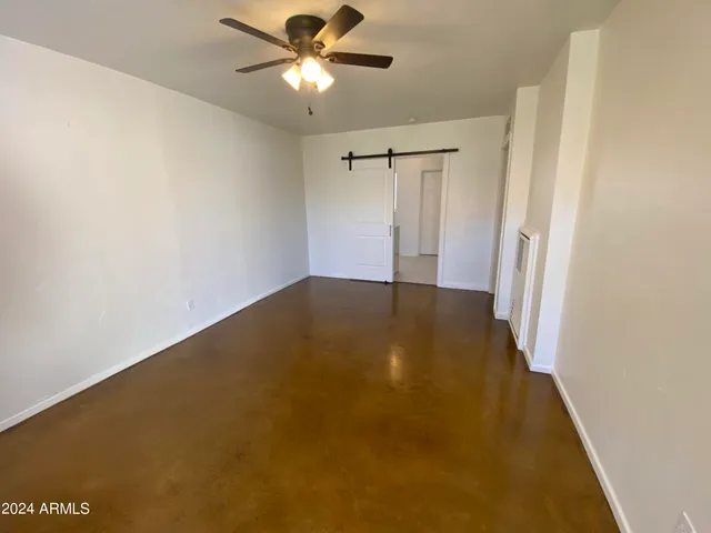 an empty room with a ceiling fan and a window