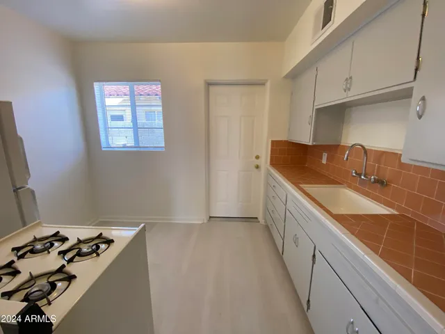 a kitchen with a sink stove and cabinets