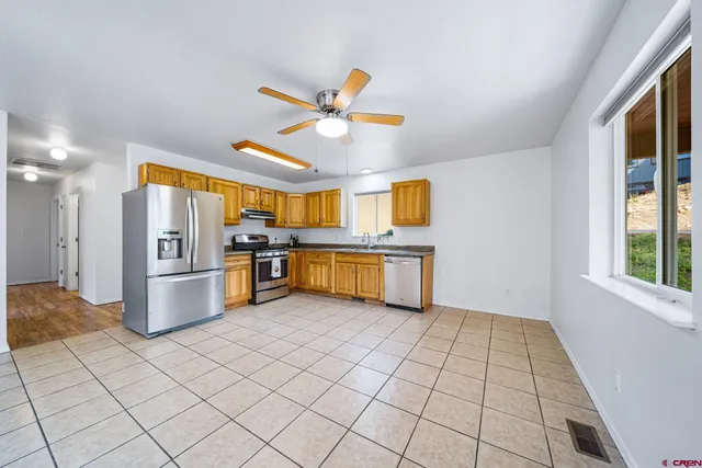 a kitchen with stainless steel appliances granite countertop a refrigerator and a sink