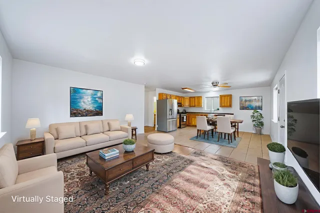 a living room with furniture a flat screen tv and a table