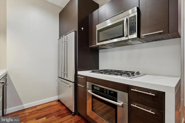 a kitchen with a sink and wooden floor