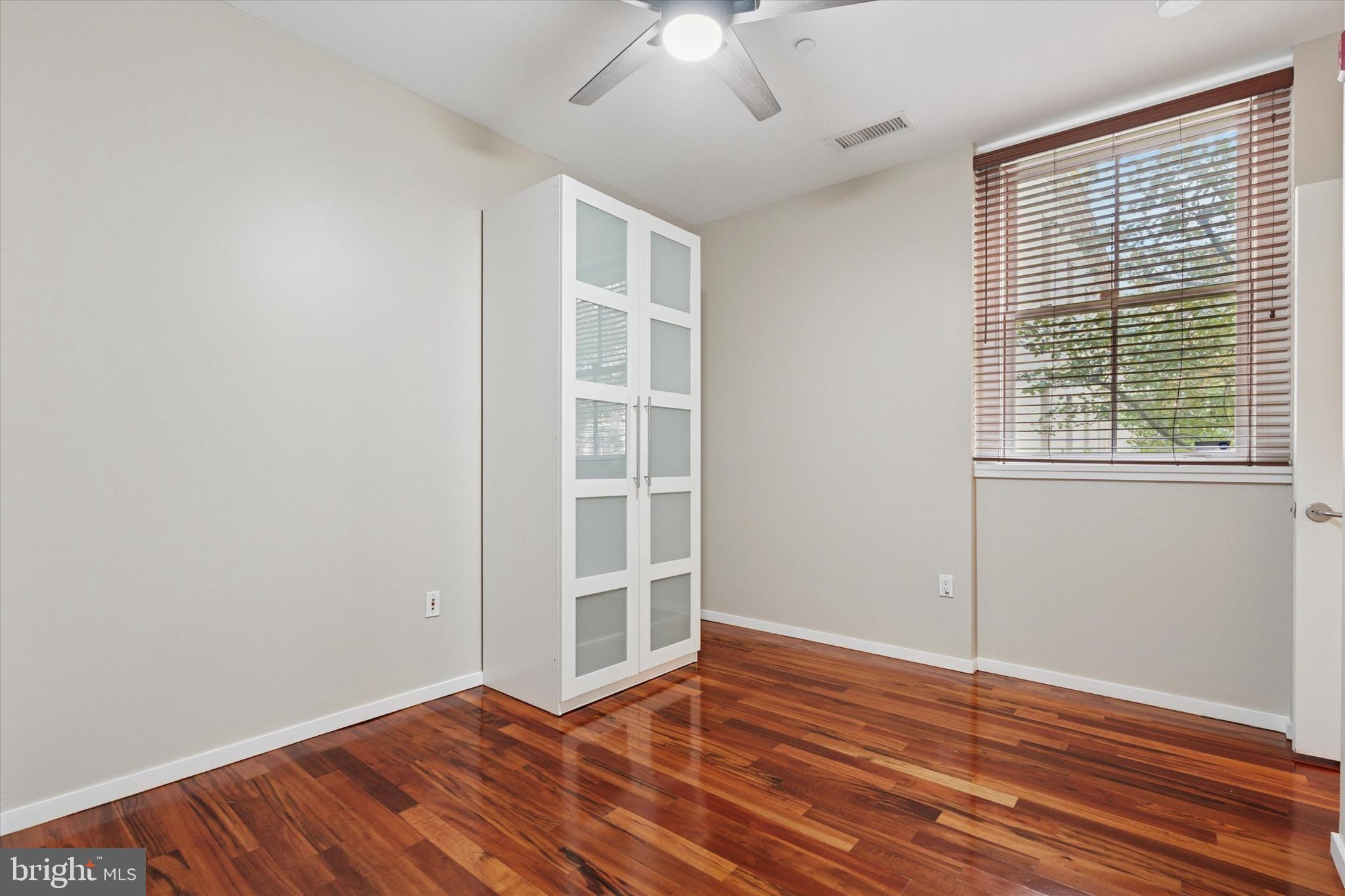 4200 Pine Street, Unit 103 Philadelphia, PA 19104 - Photo 33 of 35 an empty room with wooden floor chandelier fan and windows