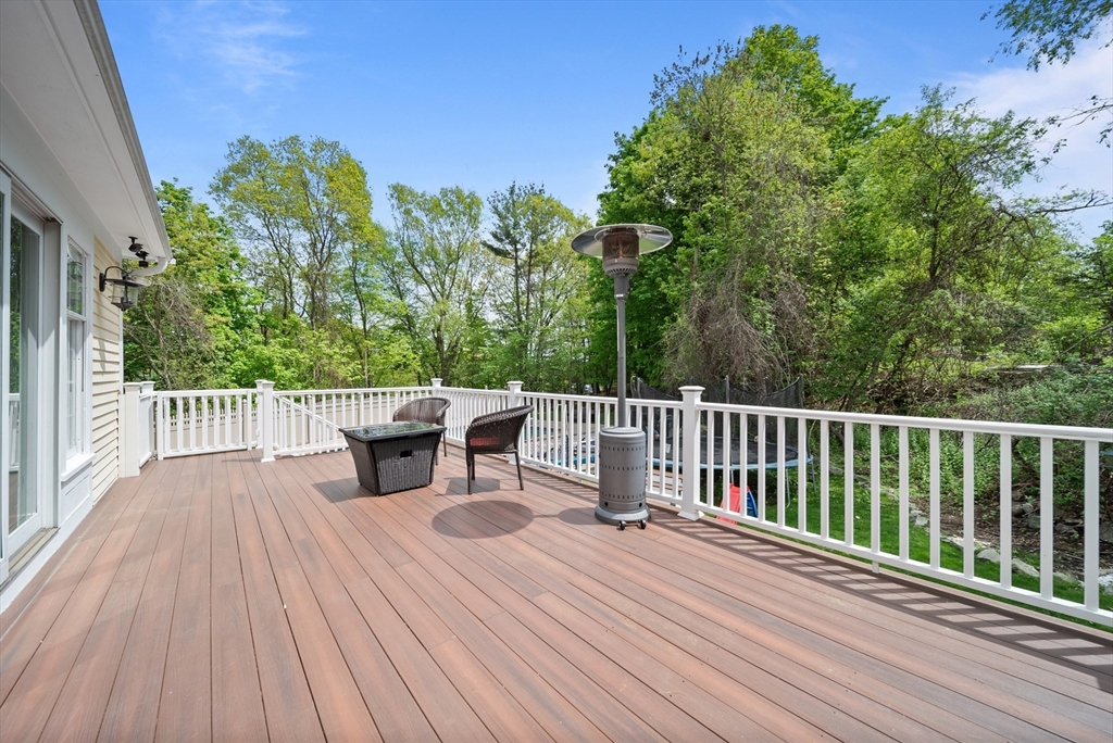 87 Hammersmith Drive Saugus, MA 01906 - Photo 16 of 37 a view of a deck with wooden floor and fence with a large tree