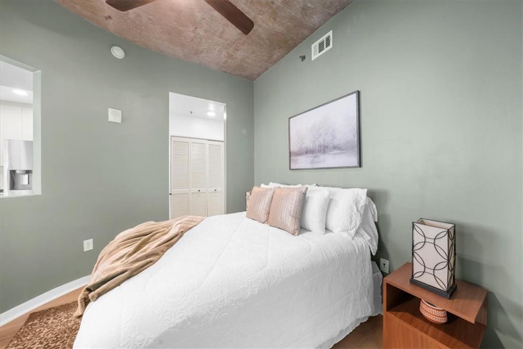 250 Pharr Road Northeast, Unit 704 Atlanta, GA 30305 - Photo 22 of 53 a bedroom with a bed and wooden floor