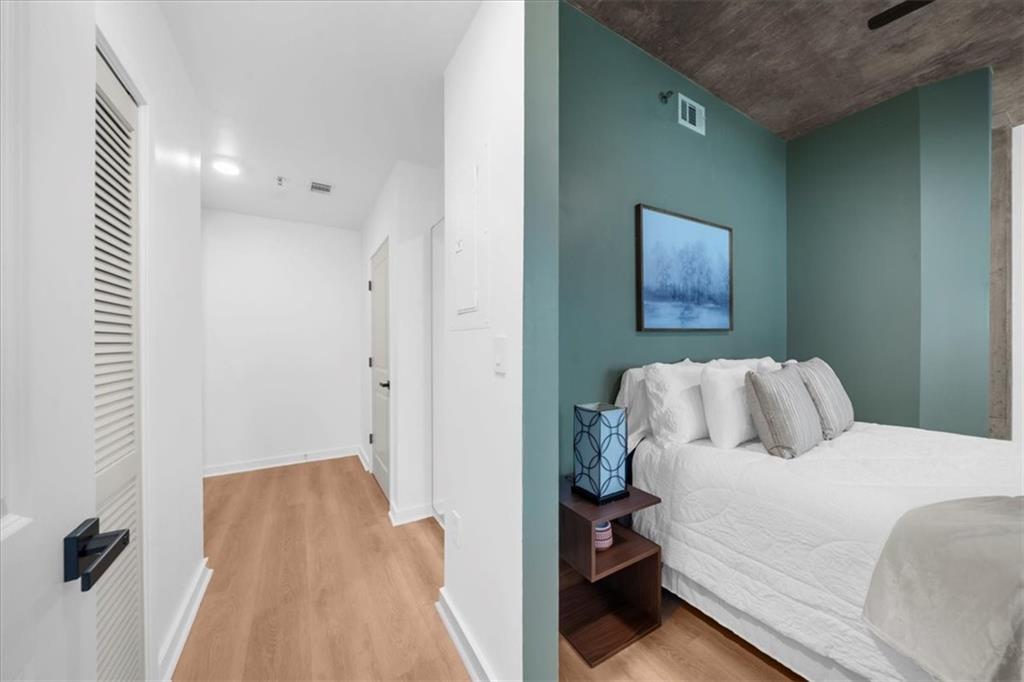 250 Pharr Road Northeast, Unit 704 Atlanta, GA 30305 - Photo 26 of 53 a bedroom with a bed and a painting on the wall