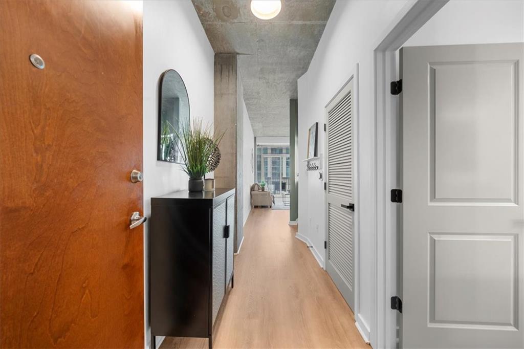 250 Pharr Road Northeast, Unit 704 Atlanta, GA 30305 - Photo 4 of 53 a view of a hallway with wooden floor and a living room