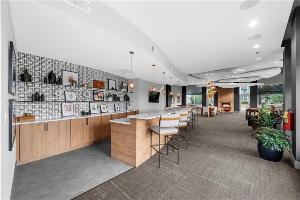250 Pharr Road Northeast, Unit 704 Atlanta, GA 30305 - Photo 41 of 53 a open kitchen with stainless steel appliances kitchen island granite countertop a table and chairs in it