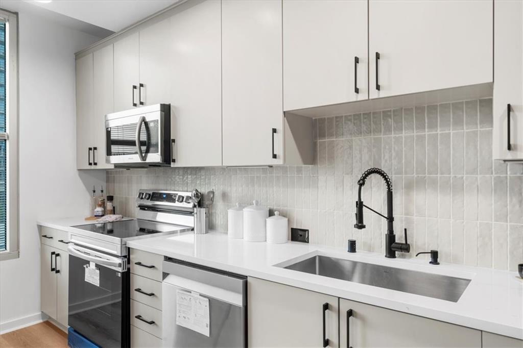 250 Pharr Road Northeast, Unit 704 Atlanta, GA 30305 - Photo 10 of 53 a kitchen with stainless steel appliances a sink a stove and cabinets