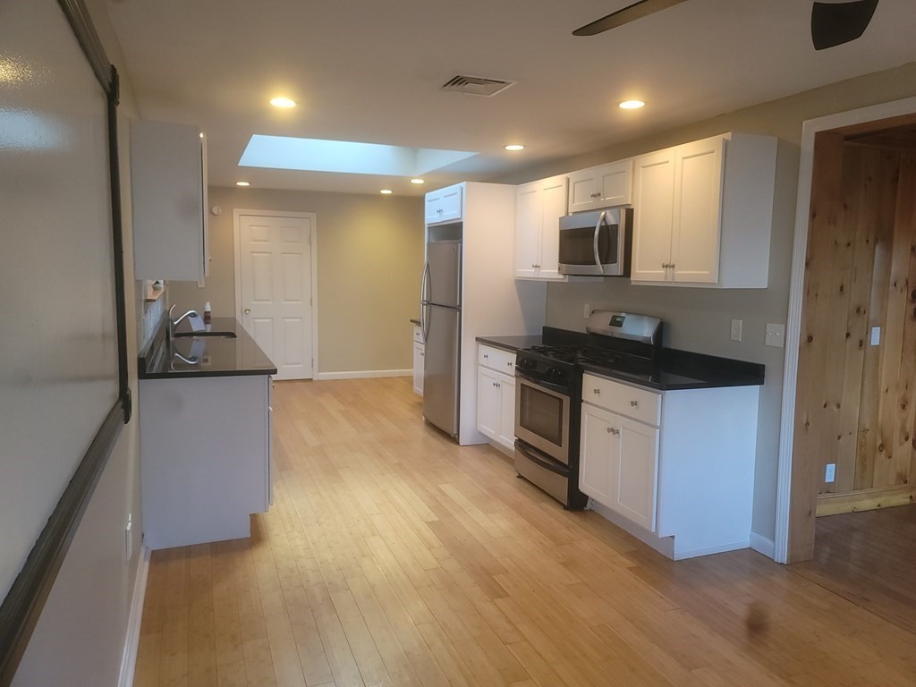 21 Kimball Road Amesbury, MA 01913 - Photo 16 of 23 a kitchen with stainless steel appliances kitchen island granite countertop a refrigerator and a stove top oven