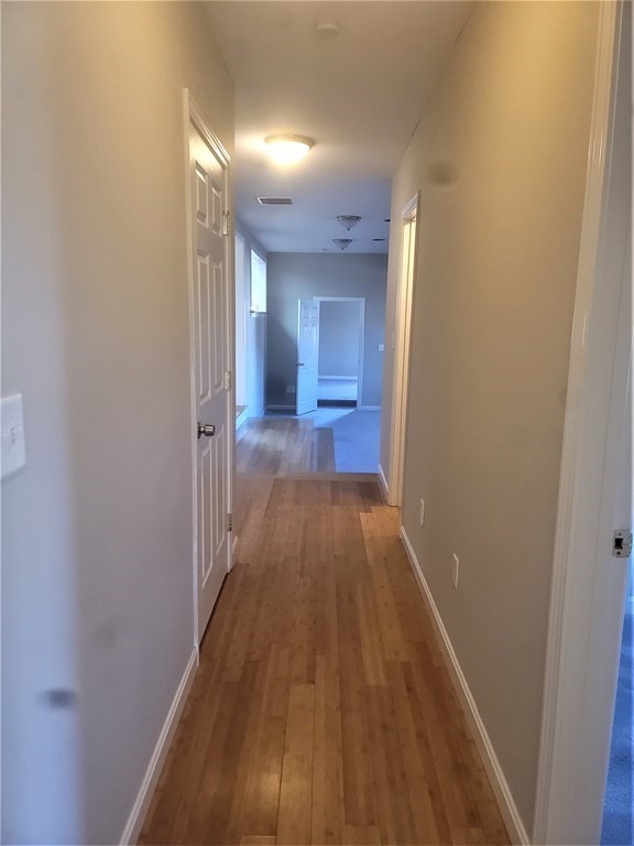 21 Kimball Road Amesbury, MA 01913 - Photo 8 of 23 a view of a hallway with wooden floor and a bathroom