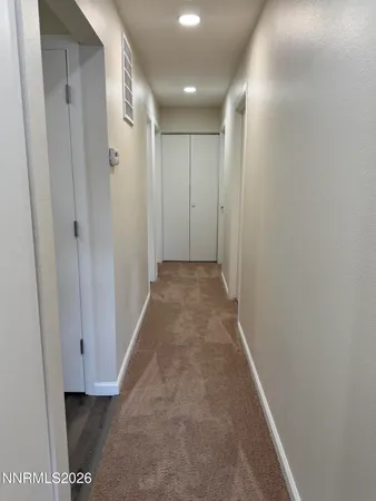 a view of a hallway with wooden floor