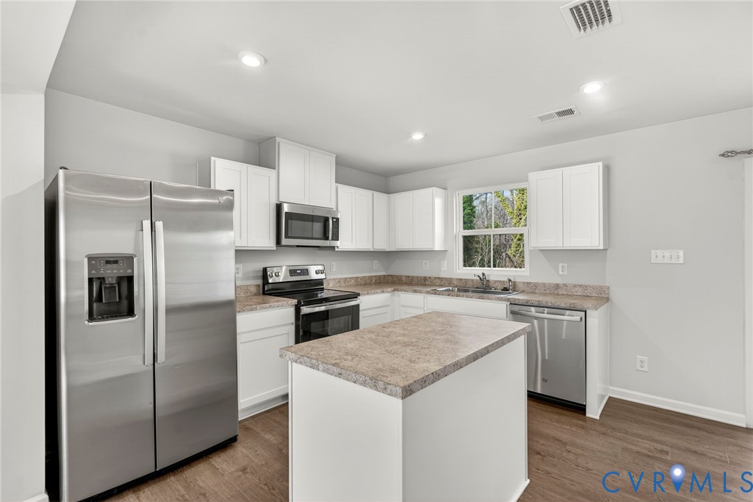 1136 Canterbury Ridge Road Richmond, VA 23224 - Photo 11 of 28 a kitchen with a stove a refrigerator and a sink