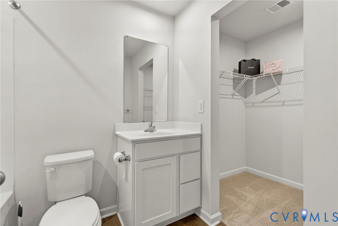 1136 Canterbury Ridge Road Richmond, VA 23224 - Photo 25 of 28 a bathroom with a toilet sink vanity and mirror