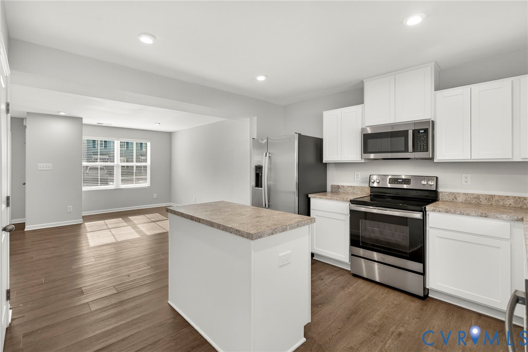 1136 Canterbury Ridge Road Richmond, VA 23224 - Photo 10 of 28 a kitchen with granite countertop a stove and a wooden floor