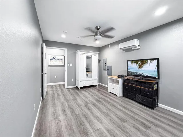 a view of a livingroom with a dresser wooden floor and a ceiling fan