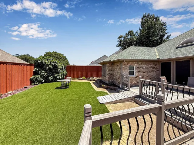 an empty room with wooden floor chandelier fan and windows