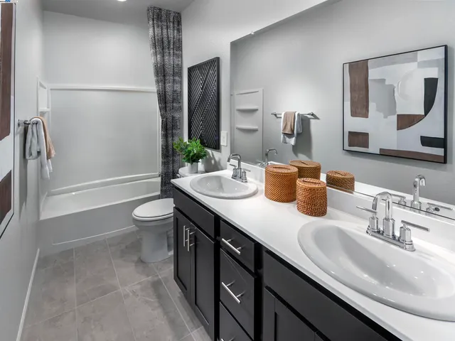 a bathroom with a granite countertop sink a toilet and shower