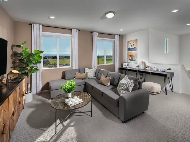 a living room with furniture potted plant a window and a flat screen tv