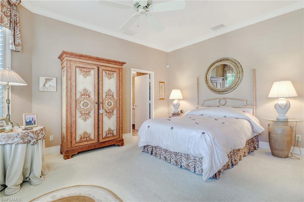 4588 Silver Fox Drive Naples, FL 34119 - Photo 19 of 35 a bedroom with a bed and a chandelier