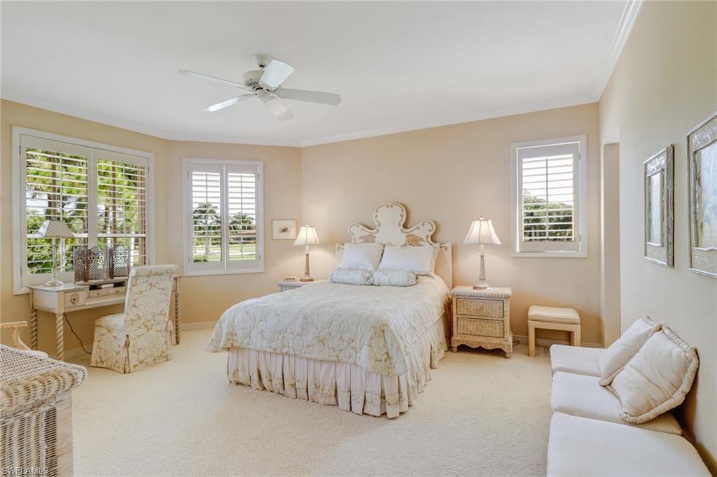 4588 Silver Fox Drive Naples, FL 34119 - Photo 22 of 35 a spacious bedroom with a bed and glass window