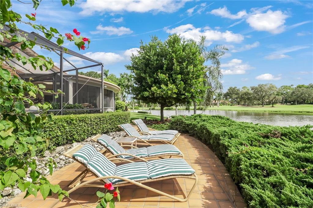 4588 Silver Fox Drive Naples, FL 34119 - Photo 32 of 35 a view of a patio with a table and chairs under an umbrella