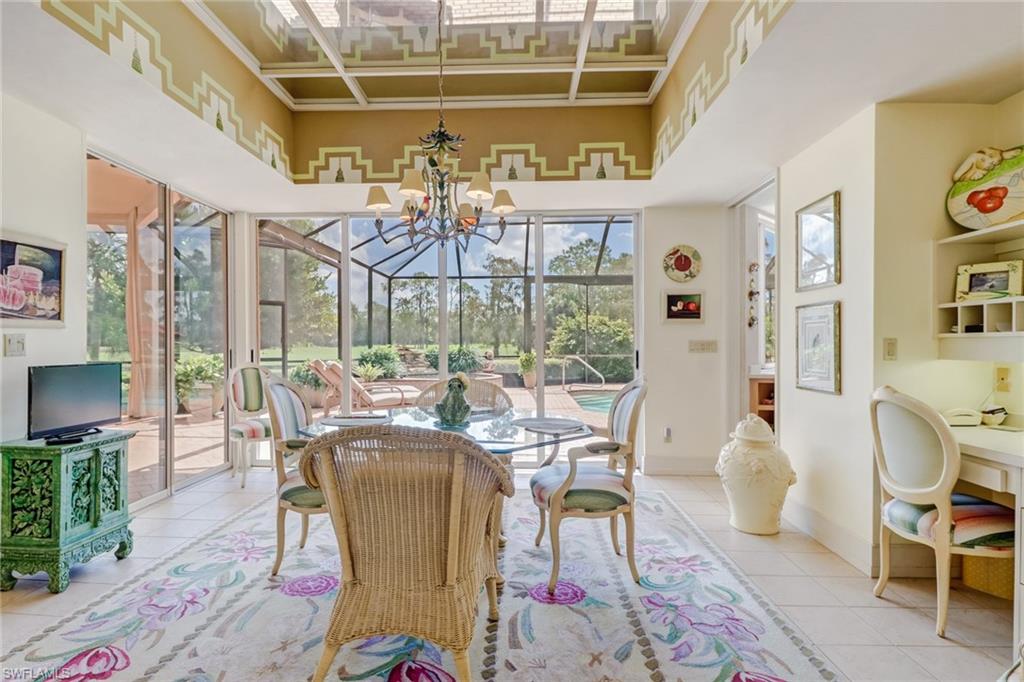 4588 Silver Fox Drive Naples, FL 34119 - Photo 8 of 35 a view of a dining room with furniture a chandelier and wooden floor