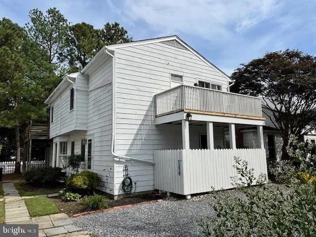 a view of a white house with a yard and potted plants