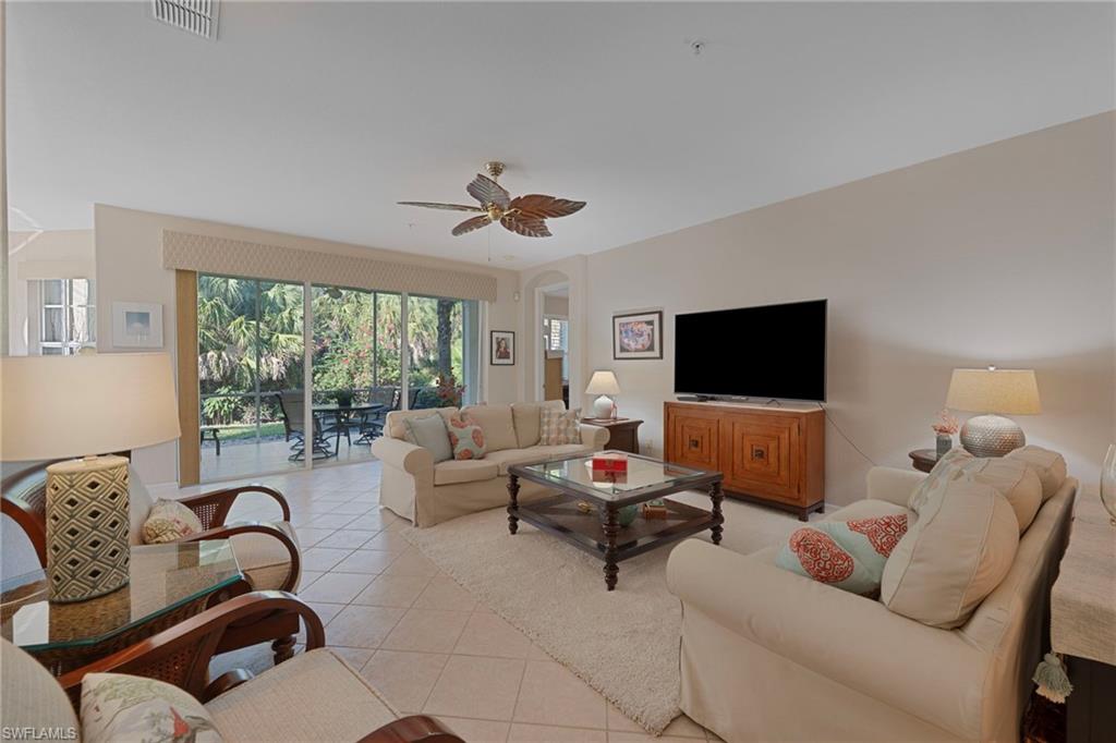 4695 Winged Foot Court, Unit 101 Naples, FL 34112 - Photo 2 of 23 a living room with furniture and a flat screen tv