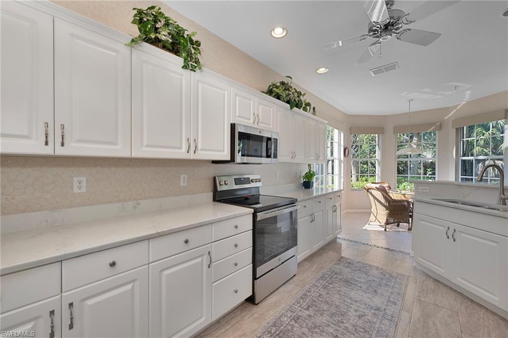 4695 Winged Foot Court, Unit 101 Naples, FL 34112 - Photo 4 of 23 a kitchen with white cabinets and appliances
