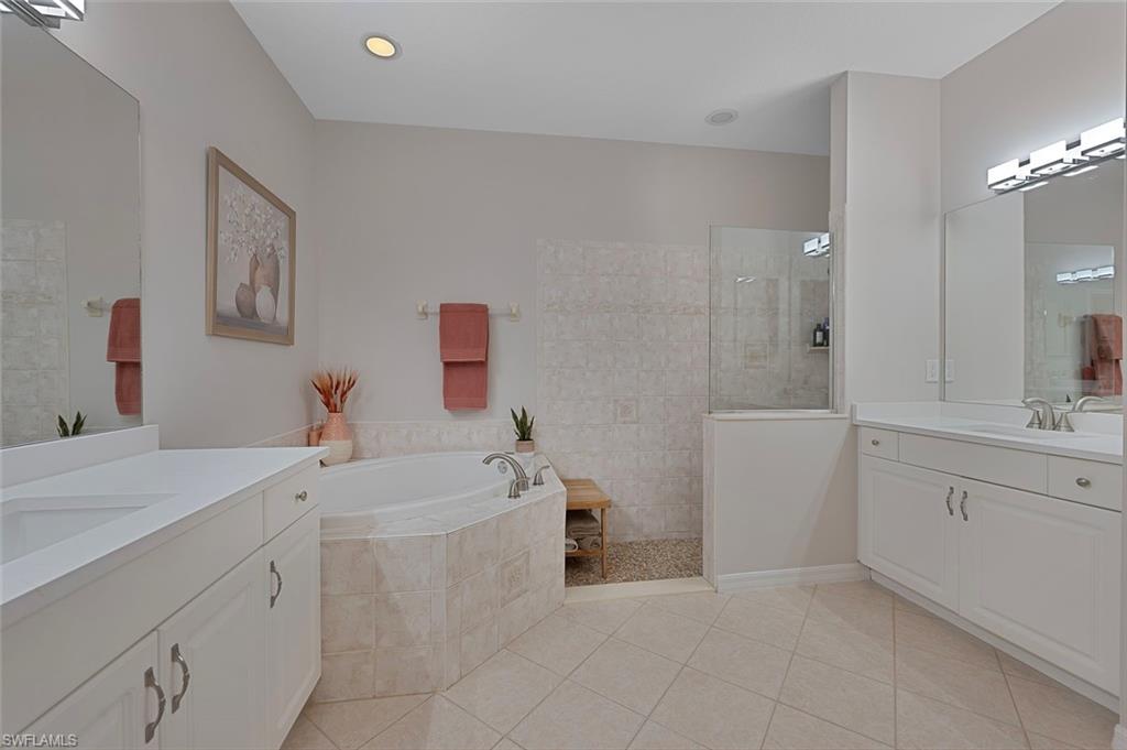 4695 Winged Foot Court, Unit 101 Naples, FL 34112 - Photo 10 of 23 a bathroom with a sink a toilet a mirror and vanity