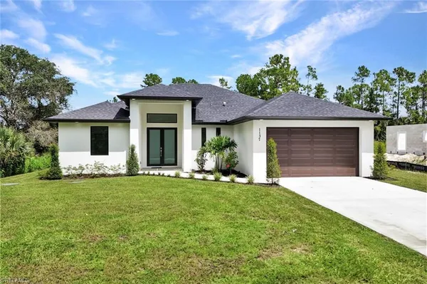 a front view of a house with a garden and yard