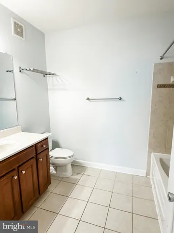 a bathroom with a granite countertop sink and a toilet