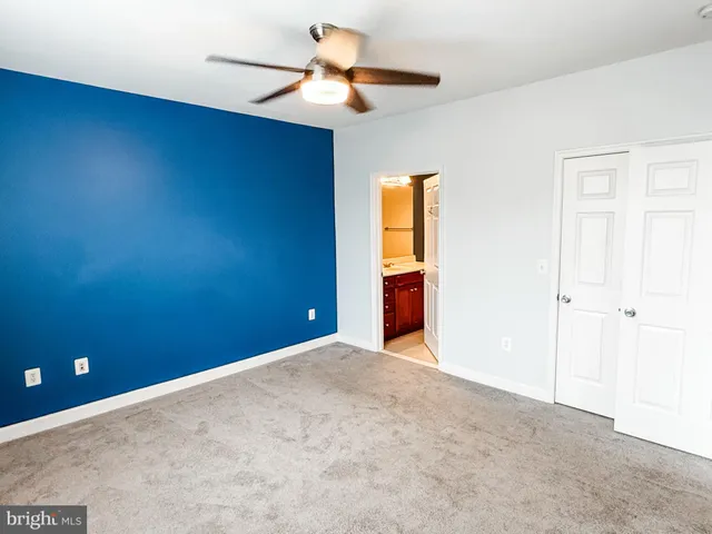 a view of an empty room and a ceiling fan