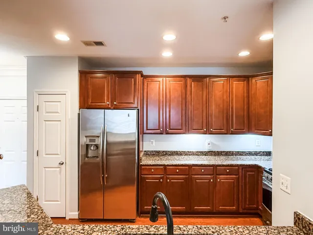 a kitchen with stainless steel appliances granite countertop a refrigerator and a sink