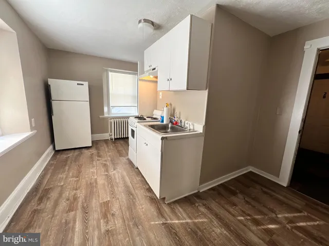 a kitchen with a sink a stove cabinets and a window