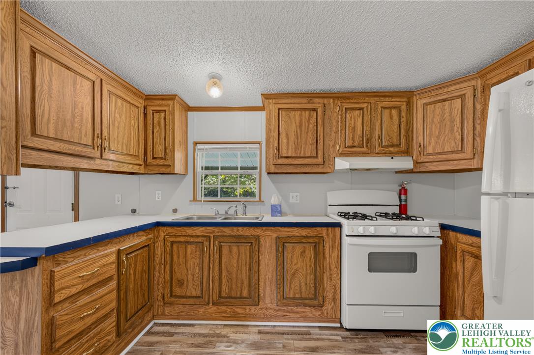 2674 Williams Road Danielsville, PA 18038 - Photo 16 of 31 A well-lit kitchen with natural wood cabinetry offers practical counter space and essential cooking facilities.