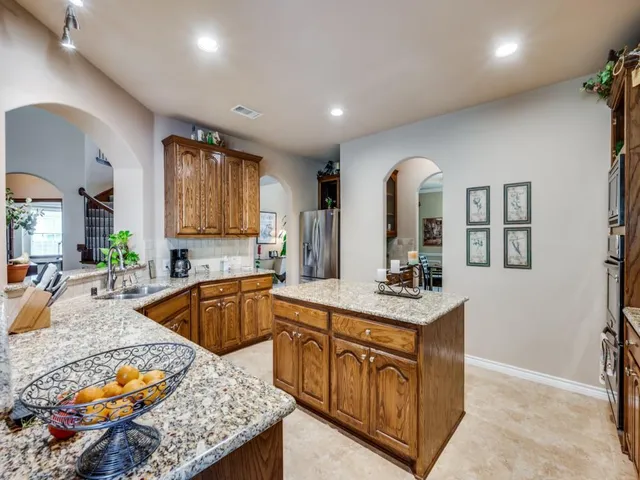 a kitchen with stainless steel appliances granite countertop a sink stove and cabinets