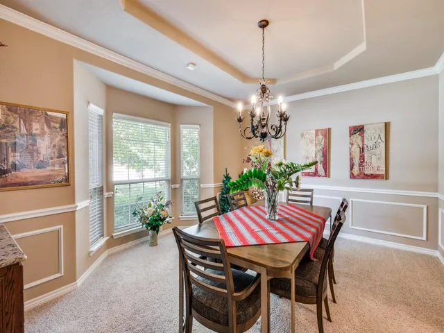 a dining room with furniture a chandelier and window