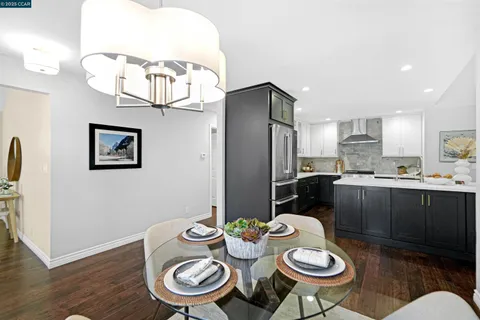 a kitchen with stainless steel appliances a dining table and chairs