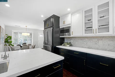 a kitchen with stainless steel appliances a sink dishwasher stove refrigerator and cabinets