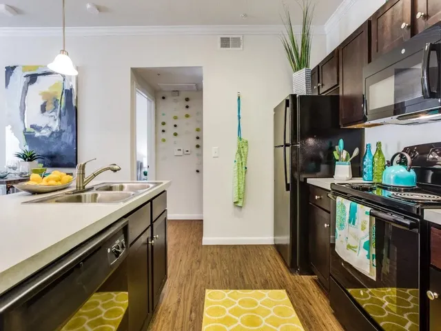 a kitchen with stainless steel appliances granite countertop a stove a sink and a refrigerator