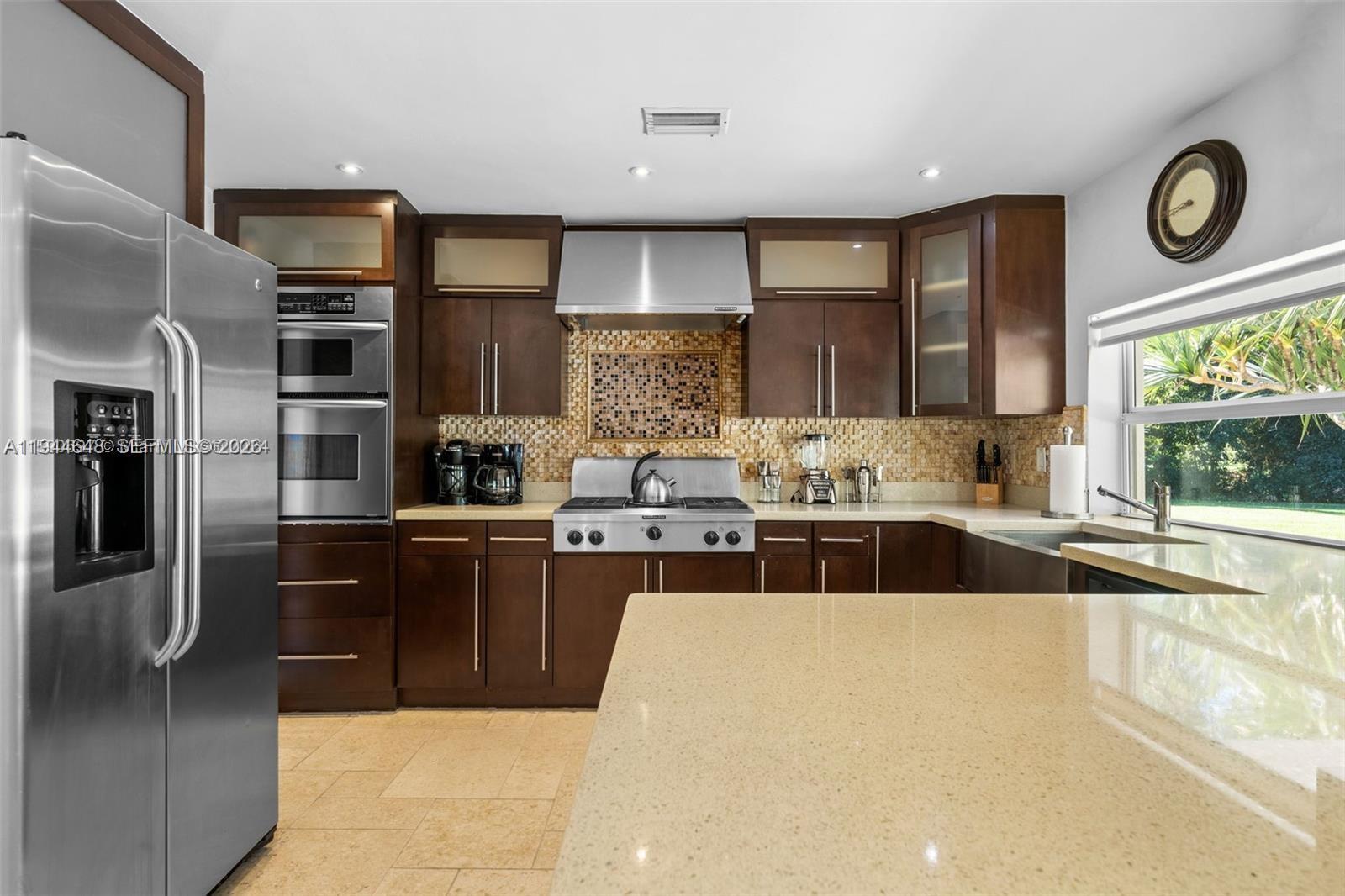 6411 Southwest 185th Way Southwest Ranches, FL 33332 - Photo 16 of 32 a large kitchen with stainless steel appliances granite countertop a stove a sink and a refrigerator